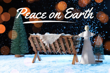 Fototapeta premium Manger with baby Jesus, angel and Christmas trees on snow against dark background