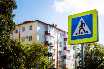 Close-up of crosswalk sign outside multi-family houses.
