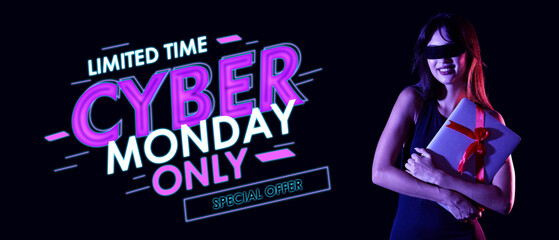 Young woman in AR glasses with gift laptop on dark background. Cyber Monday