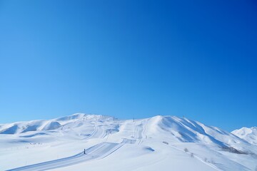 Snow covered mountains under clear blue sky on a bright sunny winter day in the alps