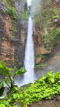 Koban Kapas Biru is a waterfall in the tropical jungles of East Java, descending from a high cliff into a lush green canyon surrounded by tropical forests with vibrant vegetation.Lumajang River. 4К