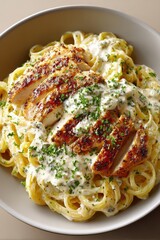Fototapeta premium Creamy garlic pasta topped with grilled chicken and parsley on ceramic plate, minimalist overhead food photography with clean background
