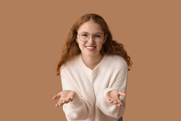 Obraz premium Portrait of confused young woman on brown background