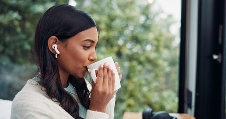 Thinking, woman and drink coffee with earphones in home, streaming music or enjoy morning beverage. Tea, audio or Indian person in house for relax, reflection or listen to radio on weekend with bokeh