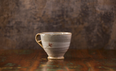 Traditional, handcrafted ceramic on wooden background.	Soft focus. Copy space. 