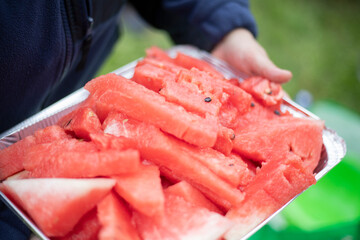 Watermelons are cut into slices. Watermelons on an aluminum tray. Juicy berries.