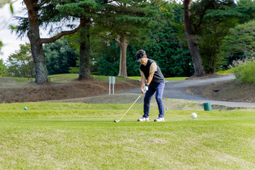 ゴルフを楽しむ日本人のミドル男性