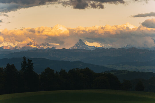Matterhorn mountain peaks glowing under sunset clouds - Powered by Adobe