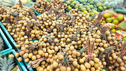 Longan Display: A bountiful market display showcases a rich collection of fresh longan fruit, arranged alongside other produce. A sight for every food lover, capturing the freshness.