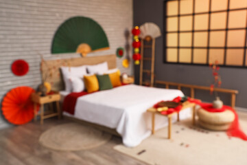 Blurred view of bedroom with bed, tables and decor for Chinese New Year celebration