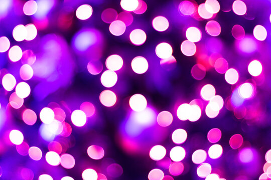 Purple bokeh background with bright, glowing magenta and pink circles, creating a vibrant, abstract, and festive light pattern - Powered by Adobe