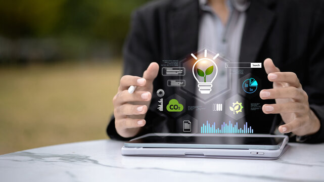 Businessman using tablet with green innovation and sustainability technology icons