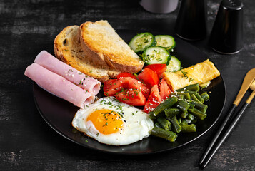 English breakfast - fried egg, ham, green beans, tomatoes, cucumbers and toast.