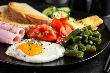 English breakfast - fried egg, ham, green beans, tomatoes, cucumbers and toast.