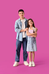 Happy brother and sister with books on purple background
