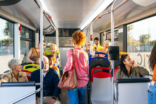 Diverse group of people commuting by public transport. Passengers riding bus during daily travel in urban setting
