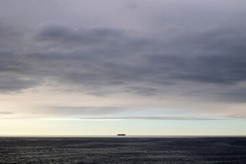 Ship on the horizon against an evening sky over the sea in Norway 