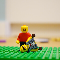 Obraz premium Lego minifigure with another minifigure lying on a green baseplate