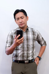 Fototapeta premium Shocked man looking at smartphone screen with surprised reaction, white background