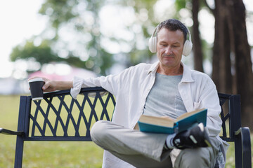 Mature man relaxing combining reading and music