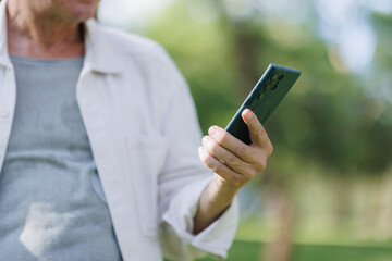 Person holding smartphone using mobile device outdoors