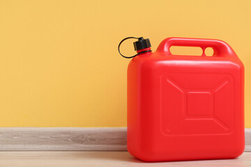 Red plastic canister near yellow wall