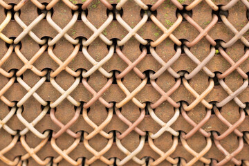 Close-up of rusty wire mesh fence weaving pattern