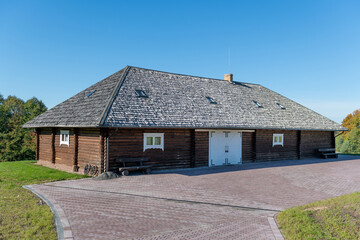 Rustic Wooden Cottage Building With Shingled Roof on a Sunny Day