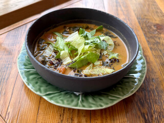 Vegan soup with black rice, tomatoes, bok choy, coconut milk and spices - vegan food concept. Handmade phone photo, selective focus, no AI