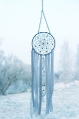 winter landscape with beautiful white dream catcher covered crystallized snow, abstract nature background. Shaman native amulet, symbol protection of dreams. Magic Spiritual talisman for soul relax.