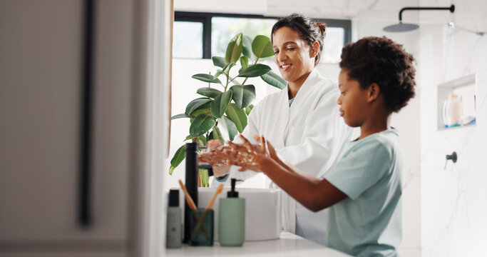 Washing hands, child and mother in bathroom for hygiene, learning and bacteria safety. Parent, boy and soap by sink in home for germ prevention, health and cleaning with happy family together - Powered by Adobe