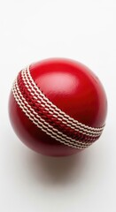 Classic Red Cricket Ball with Visible Seam Detail Resting on Reflective White Studio Surface Close Up