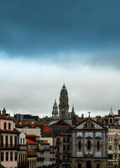 A cityscape with buildings and a cloudy sky.