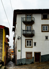 A view of a narrow street in Porto, Portugal, with buildings on either side and a cobblestone path.