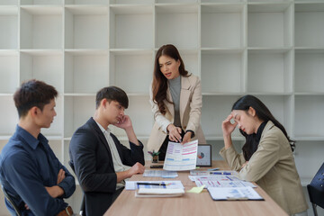 Businesswoman arguing with frustrated team in meeting