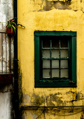 A green window on a yellow wall