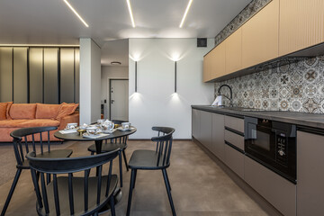 Modern Kitchen Interior with Patterned Tiles and Orange Sofa