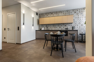 Modern Kitchen with Patterned Wall Tiles and Black Dining Set