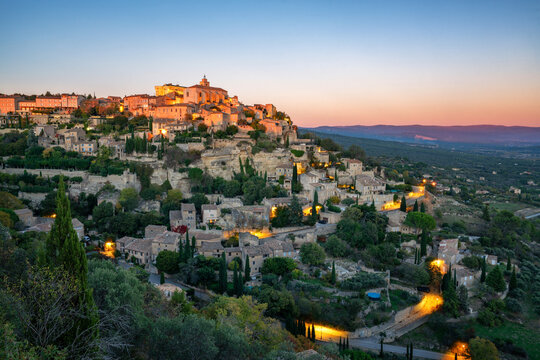Gordes historic village illuminating at sunset in France