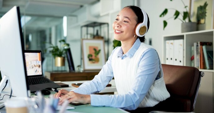 Happy woman, typing or listening with headphones for music, audio streaming or podcast in office. Female person, administrator or vibe with smile for sound playlist, tune or software app in workplace