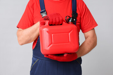 Mature male mechanic with canister on white background
