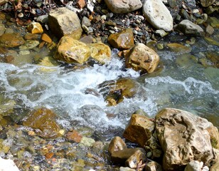Mountain stream flowing over pebbles showing purity of nature and environment balance