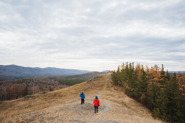 Adventurers imaging panoramic landscapes, Couple of hikers photographing stunning natural mountain scenery, Pair of trekking enthusiasts documenting scenic views in rugged mountain