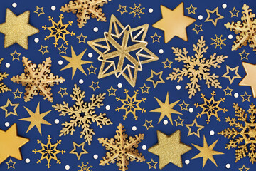 Christmas decorations gold star, snowflake, symbolic white snow flakes, background on blue. Festive design for holiday Xmas season. Greeting card.