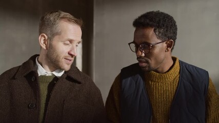 Tilt shot of two diverse male designers reviewing material palettes on site, planning colors, textures, and layouts for interior project - Powered by Adobe