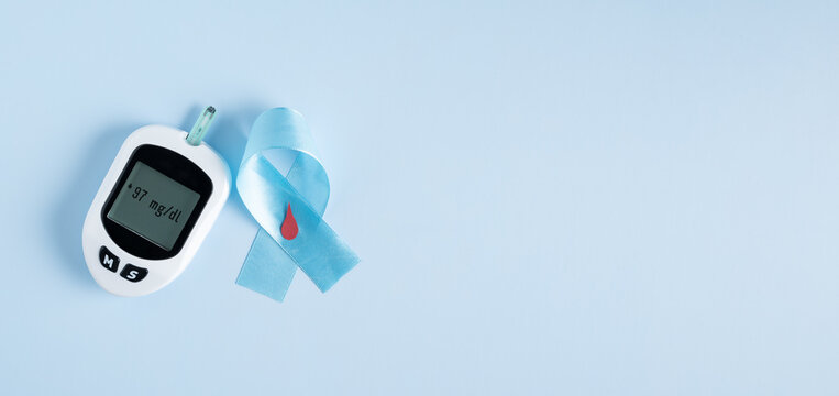 Glucometer on light blue background, crossed awareness ribbon, diabetes background, medical poster design, global awareness campaign. World Diabetes Day background with copy space.