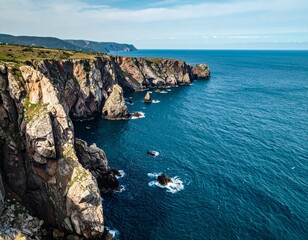 Steep coastal cliffs above blue sea showing dramatic natural marine landscape