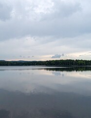 Still lake under cloudy sky showing peaceful natural reflection and landscape