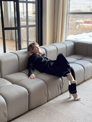 relaxed sleeping woman in soft muslin pajama having rest and nap on chair or lounger in style room decorated wooden stairs