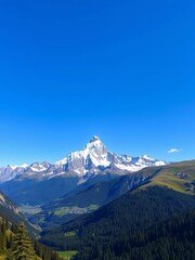 Fototapeta premium Majestic snow-capped peaks pierce a clear blue sky, a verdant valley below, serene nature, tranquil, sky